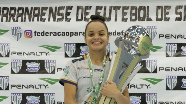 Jaque Nunes e o troféu da equipe vitoriosa do Campeonato Paranaense de Futsal Feminino (Cedida).