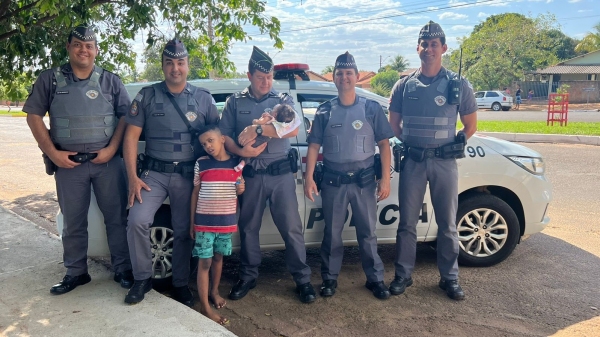 Os policiais envolvidos no resgate e as duas crianças (Imagem: Cedida).