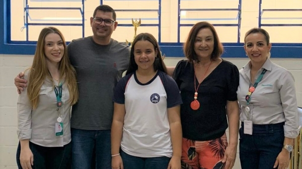 A estudante Bianca Macedo Oliveira com os representantes da Escola Cristã e do Sicoob Nosso, ao receber a premiação local (Cedida).