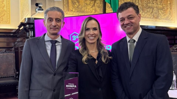 Juiza Ruth Menegatti ladeada pelo reitor da FAI Alexandre Teixeira e vice-reitor Wendel Soares na premiacao do ROMPA (Divulgacao).