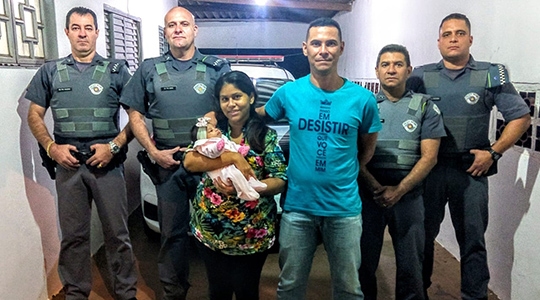 Policiais militares cabos Mazon, Redressa, Denis e soldado Goldoni, com os pais e a bebê salva (Reprodução/Tupã Notícias).